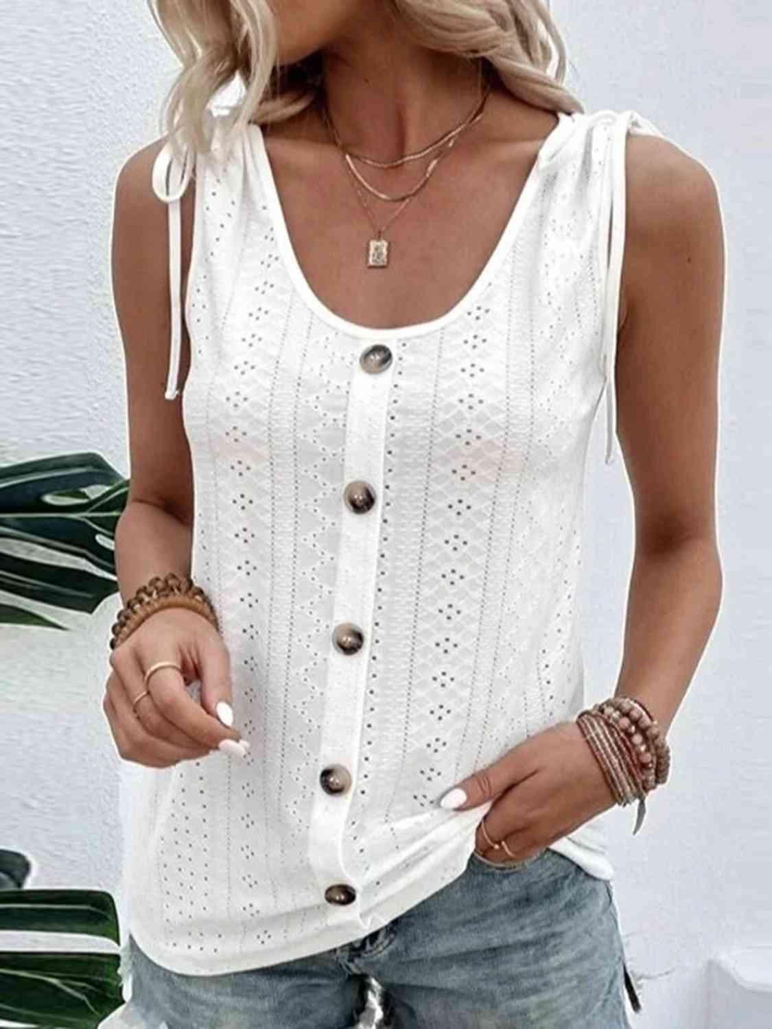 a woman wearing a white tank top and denim shorts