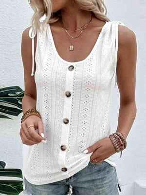 a woman wearing a white tank top and denim shorts