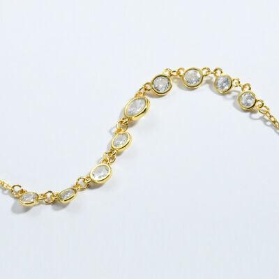 a gold bracelet with white stones on a white background