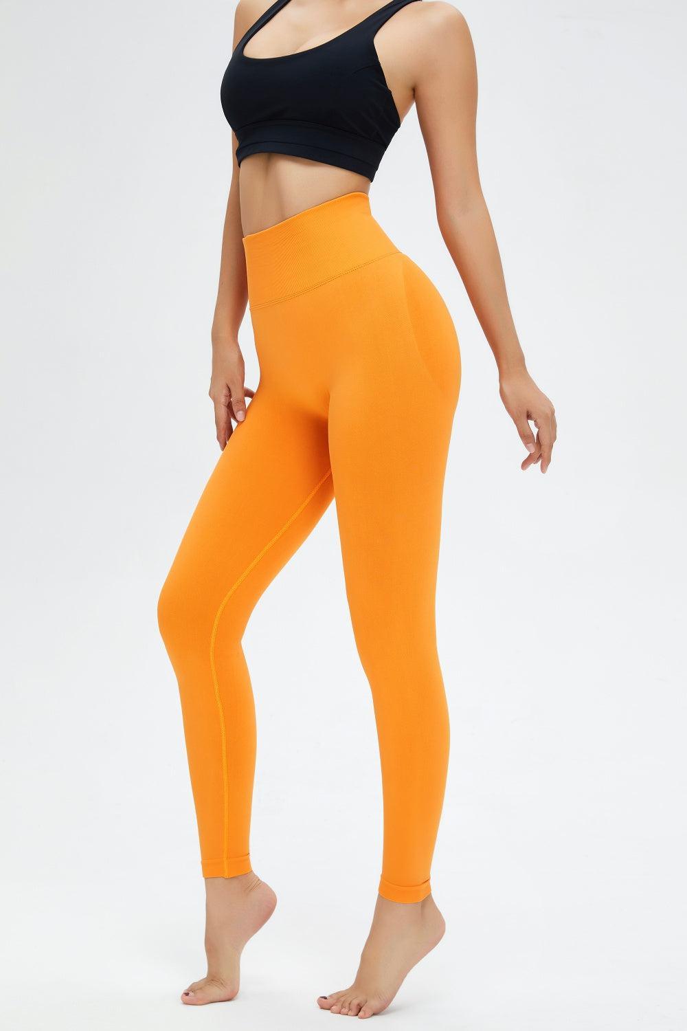 a woman in a black top and orange leggings