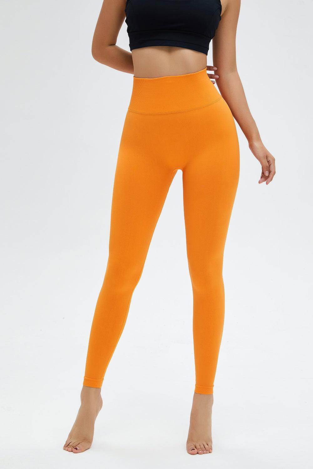 a woman in a black top and orange leggings