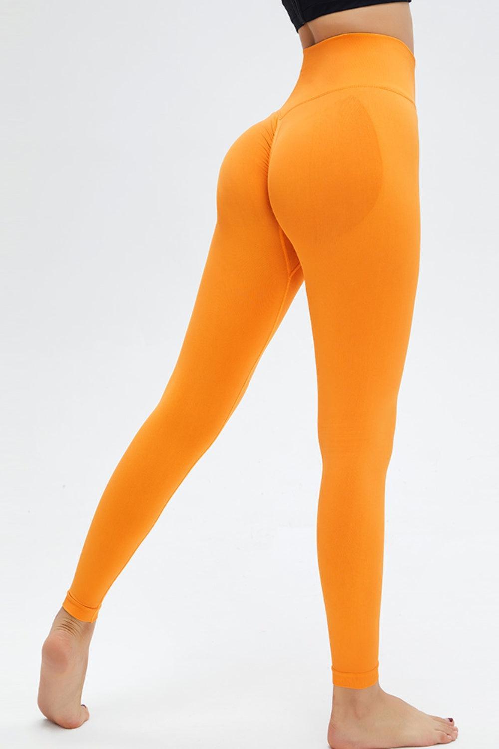 a woman in a black top and orange leggings
