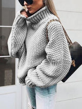 a woman in a gray sweater smoking a cigarette