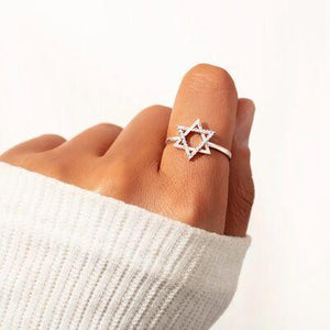 a woman's hand wearing a star of david ring