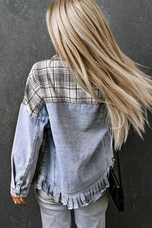 a woman with long blonde hair standing against a wall