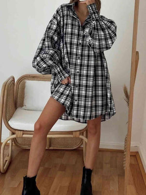 a woman wearing a black and white plaid shirt dress