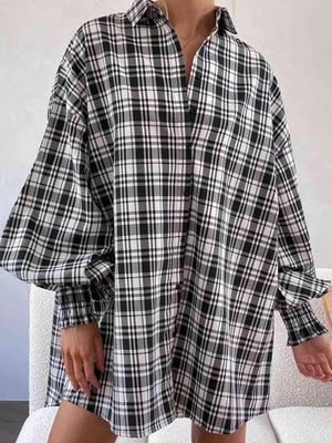 a woman wearing a black and white plaid shirt dress