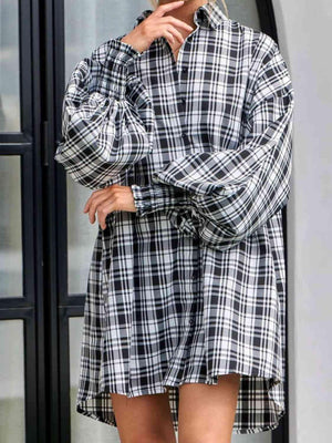 a woman wearing a black and white plaid shirt dress