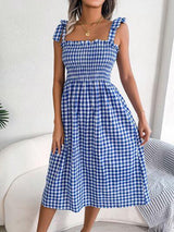 a woman wearing a blue and white checkered dress