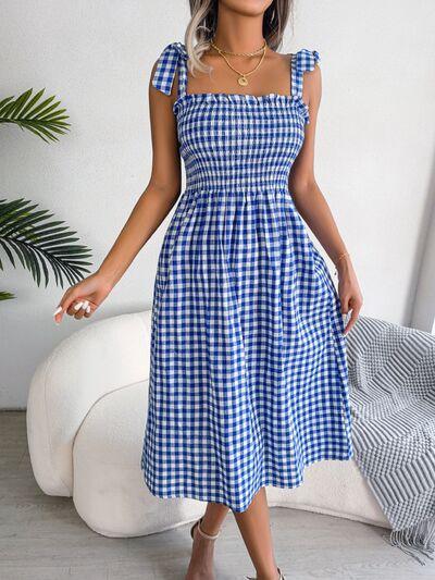 a woman wearing a blue and white checkered dress