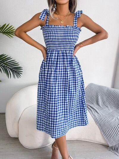 a woman wearing a blue and white checkered dress