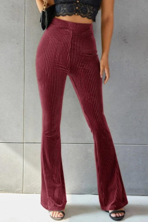 a woman wearing a crop top and wide legged pants