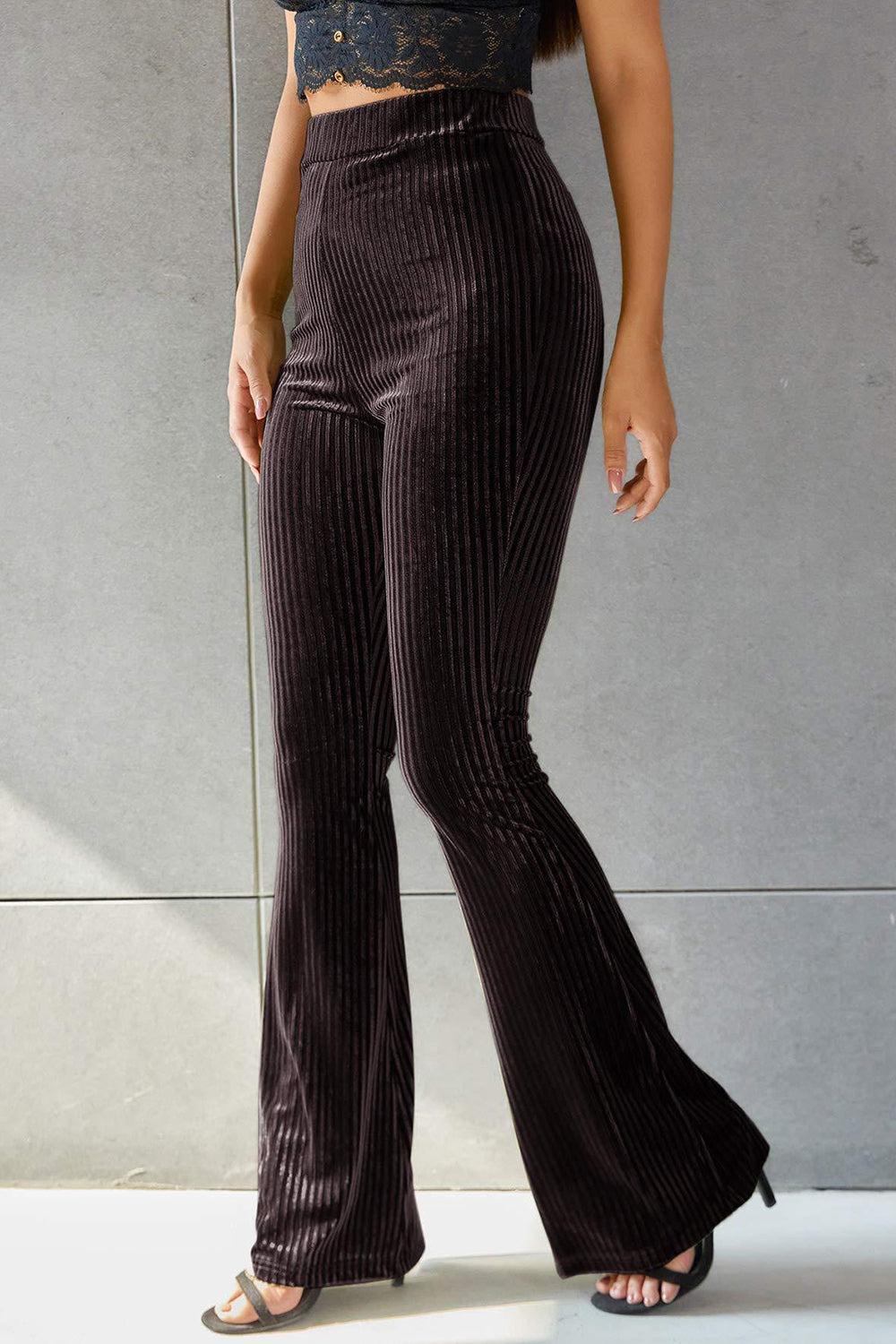 a woman wearing a crop top and wide legged pants