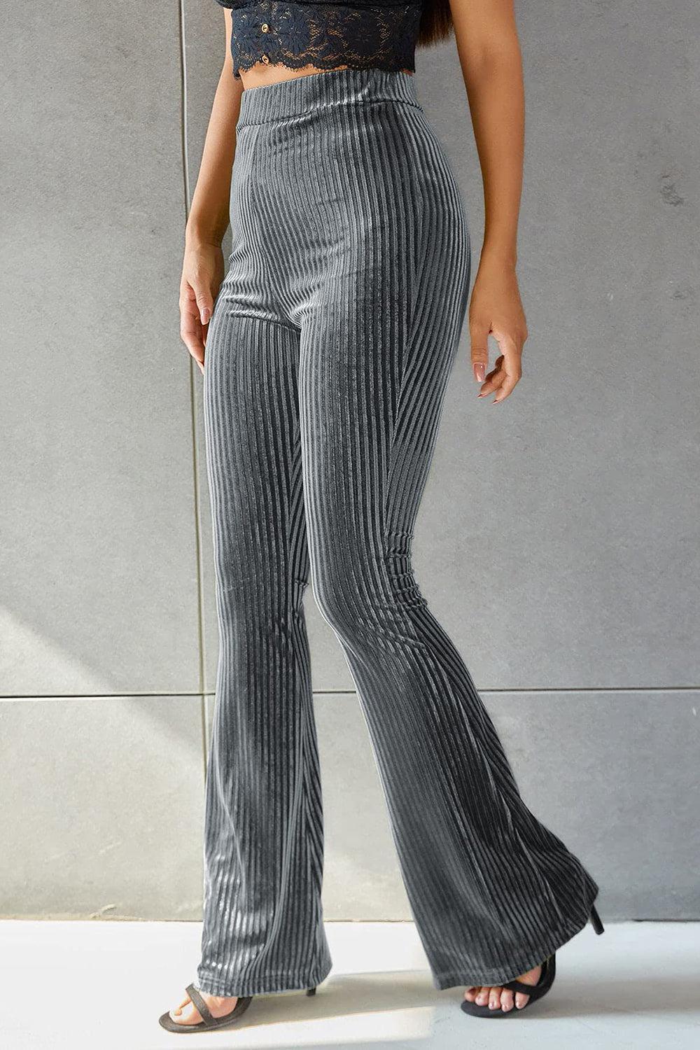 a woman wearing a crop top and wide legged pants