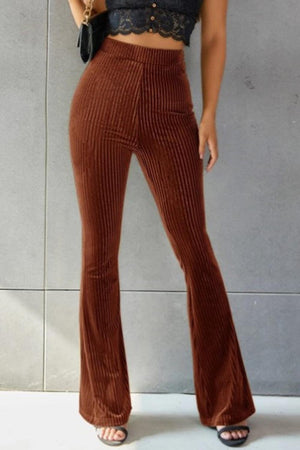 a woman wearing a crop top and wide legged pants