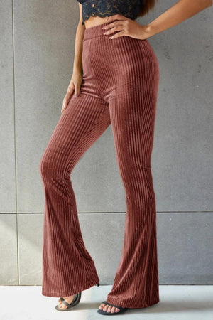 a woman wearing a crop top and wide legged pants