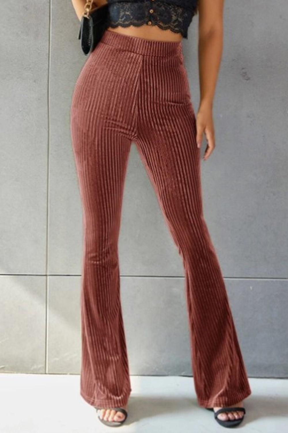 a woman wearing a crop top and wide legged pants