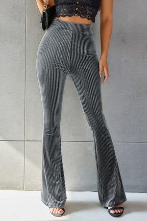 a woman wearing a crop top and wide legged pants