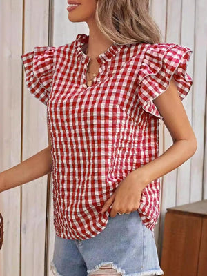 a woman wearing a red and white checkered top