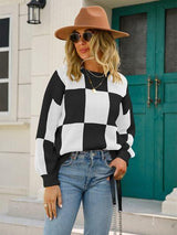 a woman wearing a black and white checkered sweater