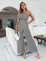 a woman wearing a black and white checkered jumpsuit