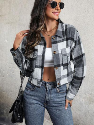 a woman wearing a plaid jacket and jeans