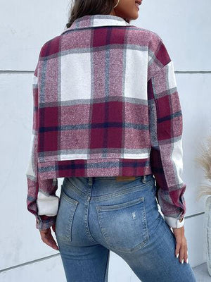 a woman wearing a plaid jacket and jeans