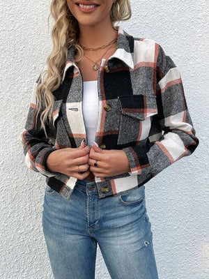 a woman standing in front of a white wall