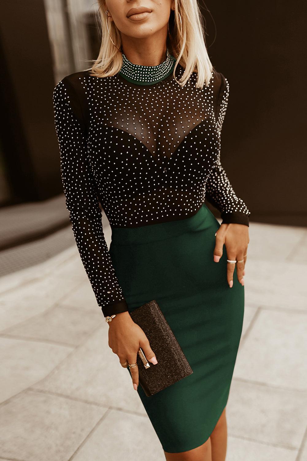 a woman in a black top and green skirt