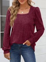 a woman wearing a burgundy sweater and jeans