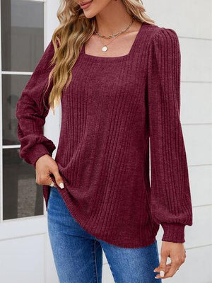 a woman wearing a burgundy sweater and jeans