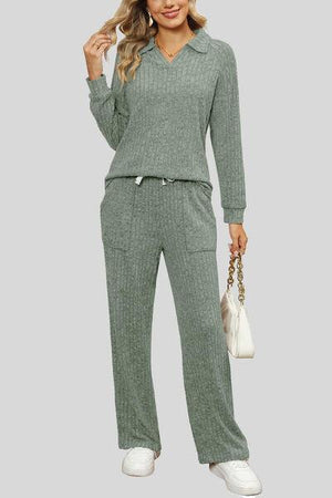 a woman wearing a green sweater and pants