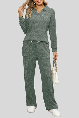 a woman wearing a green sweater and pants