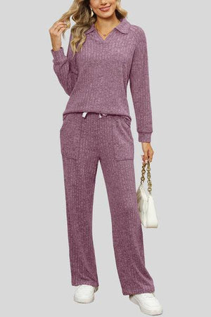 a woman wearing a purple sweater and pants