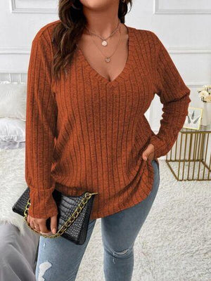 a woman wearing a brown sweater and jeans