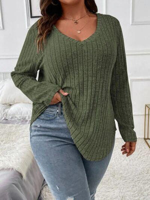 a woman wearing a green sweater and ripped jeans