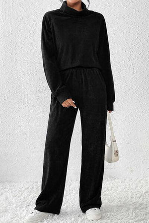 a woman wearing a black jumpsuit and white sneakers