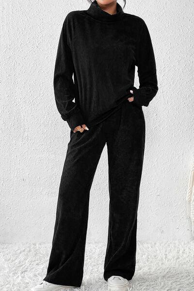 a woman wearing a black jumpsuit and white sneakers