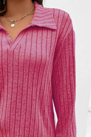 a close up of a woman wearing a pink sweater
