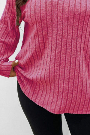 a woman wearing a pink sweater and black pants