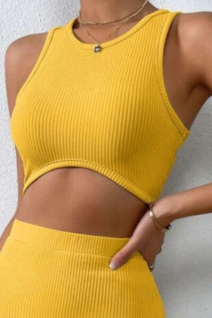 a woman wearing a yellow crop top and skirt