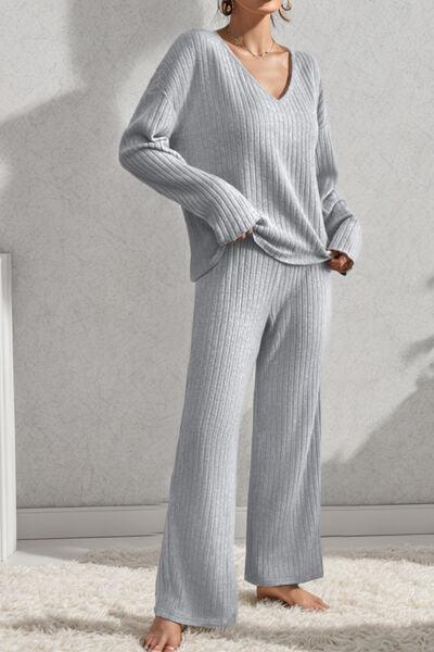 a woman standing on a rug wearing a sweater and pants