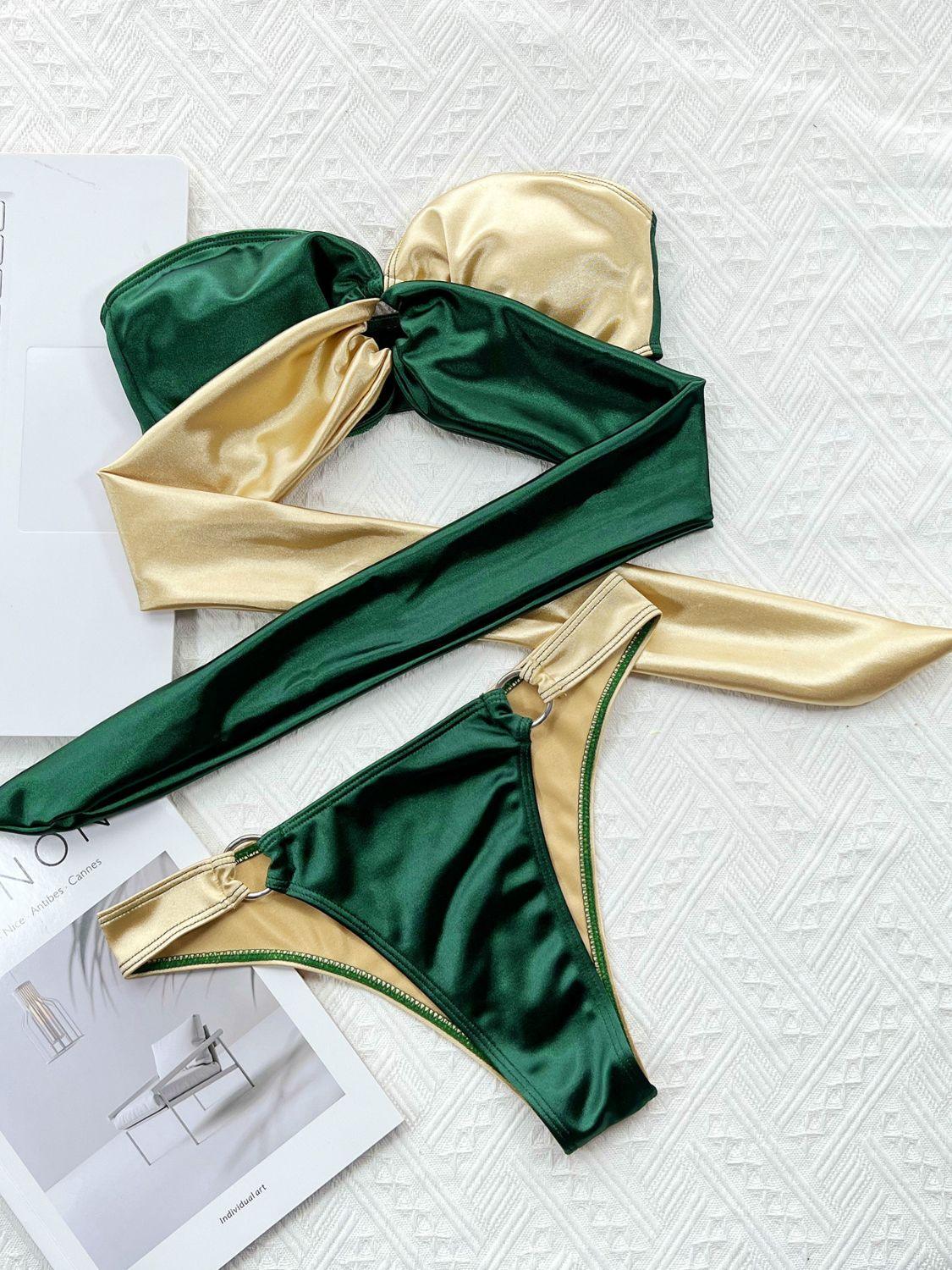 two pieces of green and gold swimsuit on a white surface