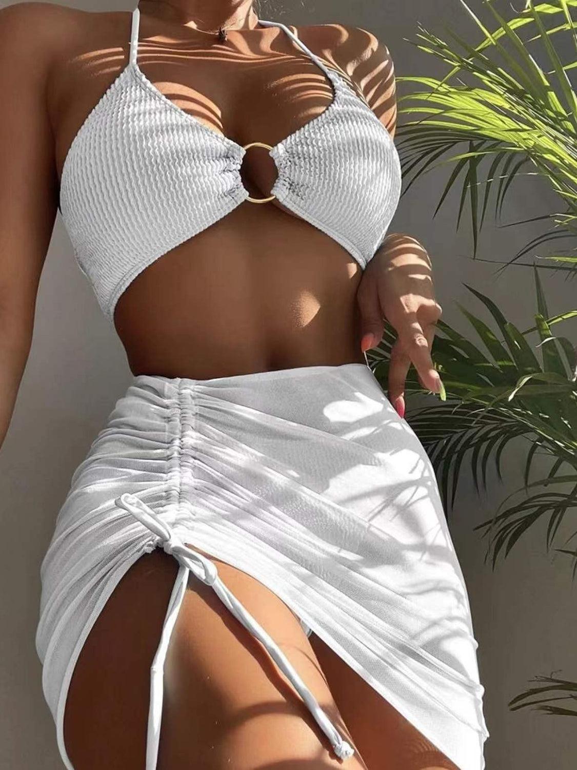 a woman in a white bikini top and skirt