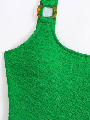 a green apron hanging on a white wall