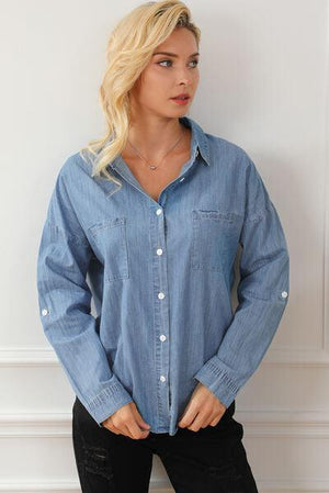a woman in a denim shirt poses for a picture