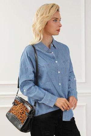 a woman in a blue shirt carrying a leopard print purse