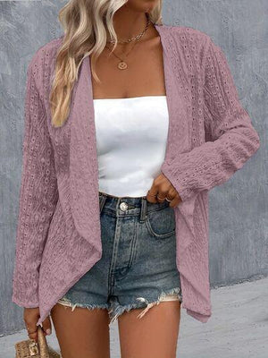 a woman wearing a pink cardigan sweater and denim shorts