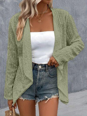 a woman wearing a green cardigan sweater and denim shorts