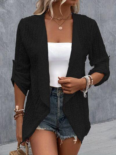 a woman wearing a black cardigan sweater and denim shorts